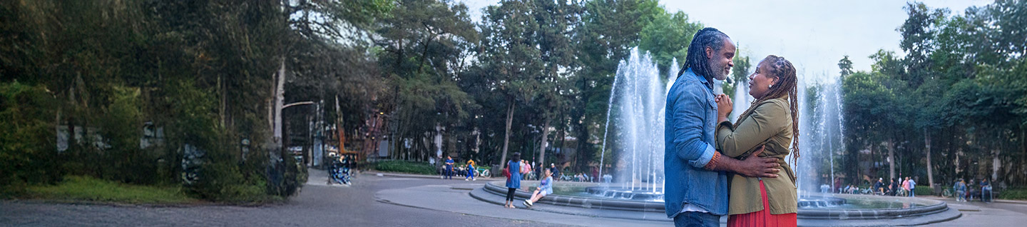 Man and woman embracing each other in front of a fountain