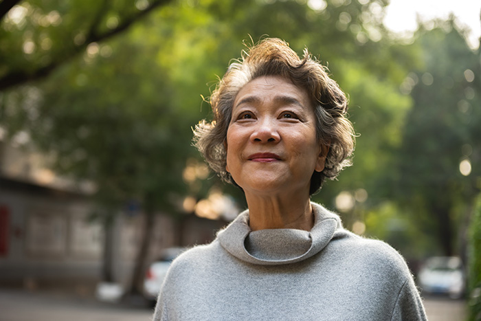 Elderly woman smiling happily outdoors