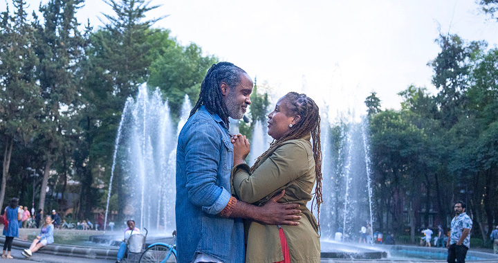 Man and woman embracing each other in front of a fountain