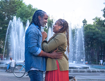 Man and woman embracing each other in front of a fountain